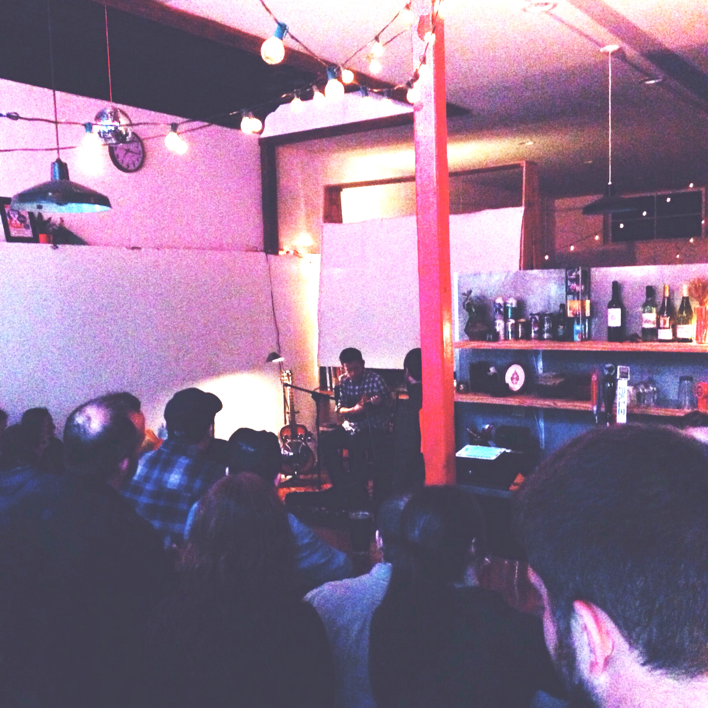 Musician David Hughes plays banjo music in front of crowd.